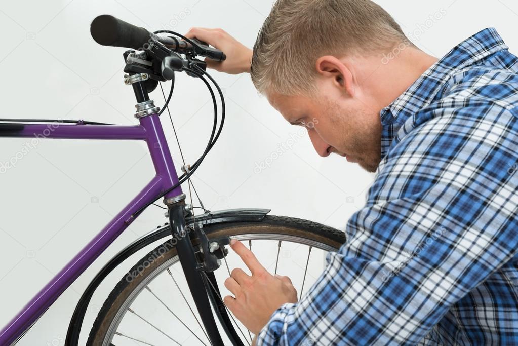 depositphotos_77886472-stock-photo-man-looking-at-bicycle-tire.jpg